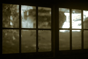 Vintage cracked window panes with sepia tone and dark interior