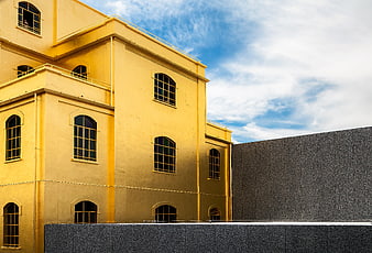 Yellow building facade with arched windows against blue sky
