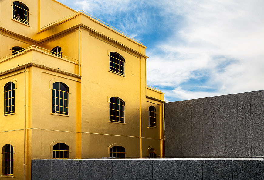 Yellow building facade with arched windows against blue sky