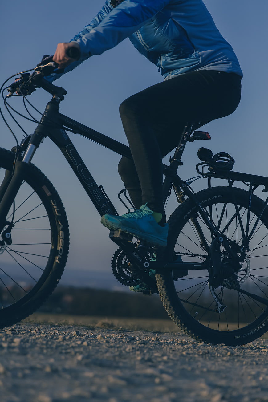 Low angle shot of cyclist riding mountain bike on gravel path
