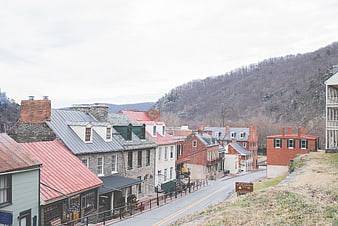 Historic village street with red roofs and mountain backdrop