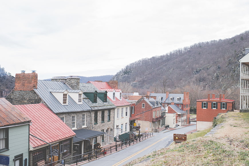 Historic village street with red roofs and mountain backdrop