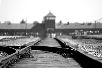 Black and white railway tracks leading to a blurred watchtower