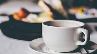 White Coffee Cup with Blurred Breakfast Background
