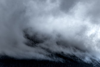 Dramatic Dark Storm Clouds Rolling Over Forested Mountain Ridge