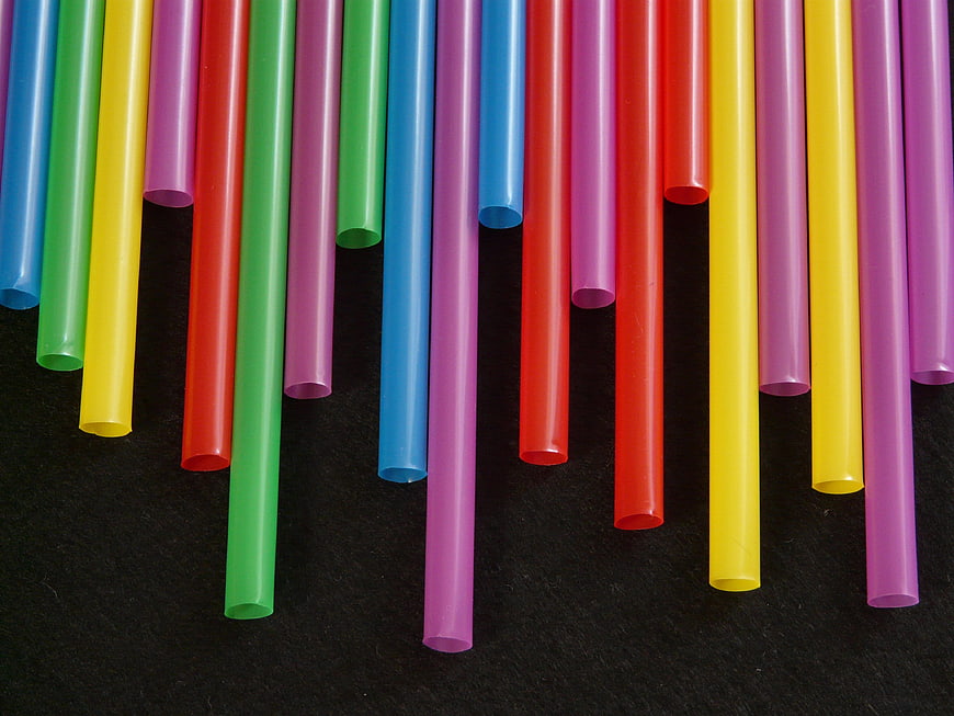 Colorful plastic drinking straws on black background