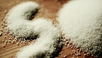 Close-up of white salt grains on a wooden surface