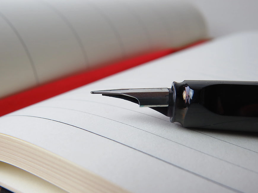 Close-up of fountain pen nib on open notebook