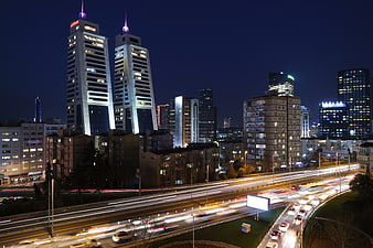 Night cityscape with long exposure highway traffic and skyscrapers