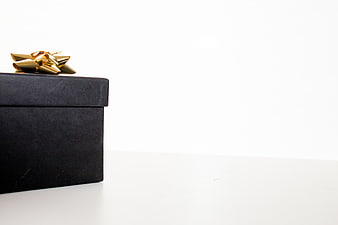 Black Gift Box with Gold Bow on White Background