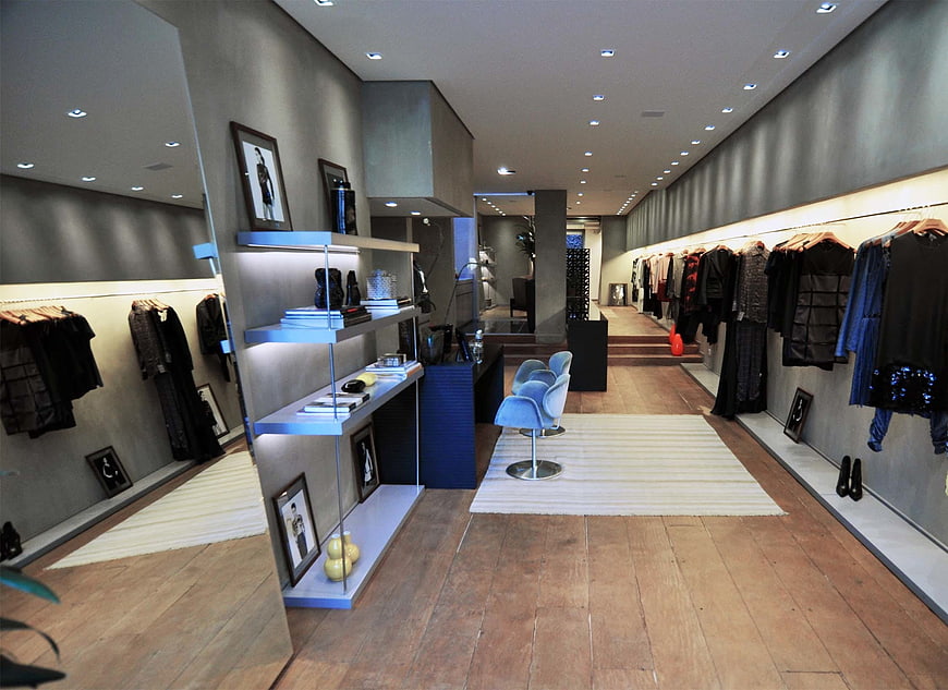 Modern Boutique Interior with Clothing Racks and Blue Chairs