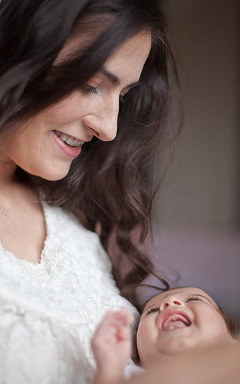 Smiling Mother Holding Laughing Newborn Baby