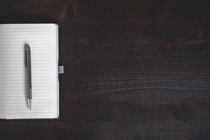 Open Notebook And Pen On Dark Wood Table With Copyspace