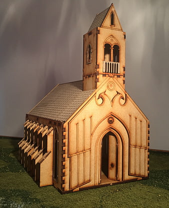 Laser-cut wooden church model on green base