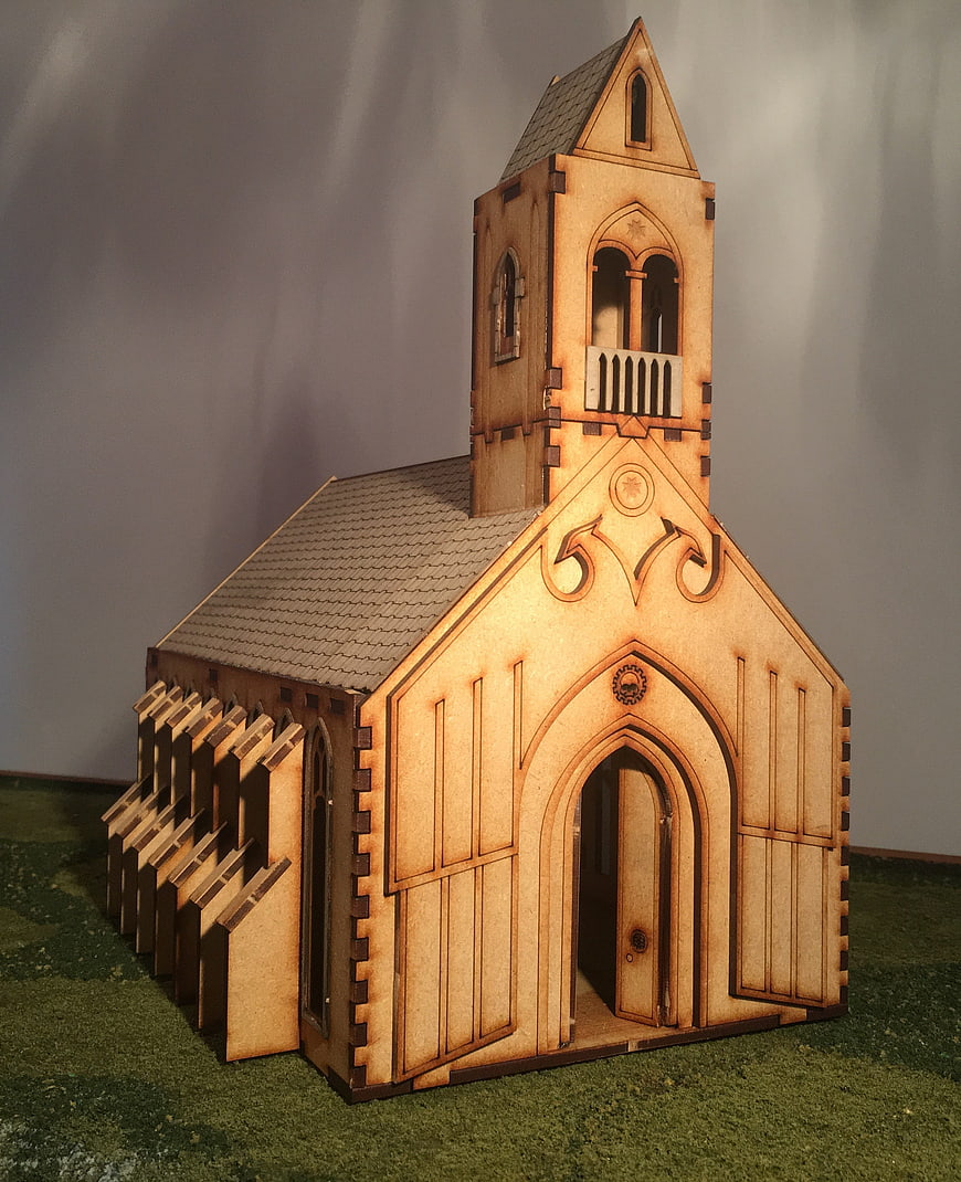 Laser-cut wooden church model on green base