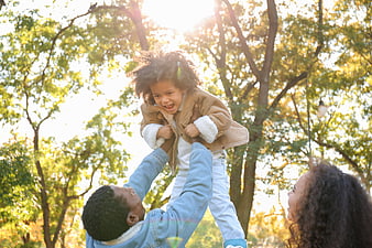 Happy African American Family Playing in Park with Sunlight
