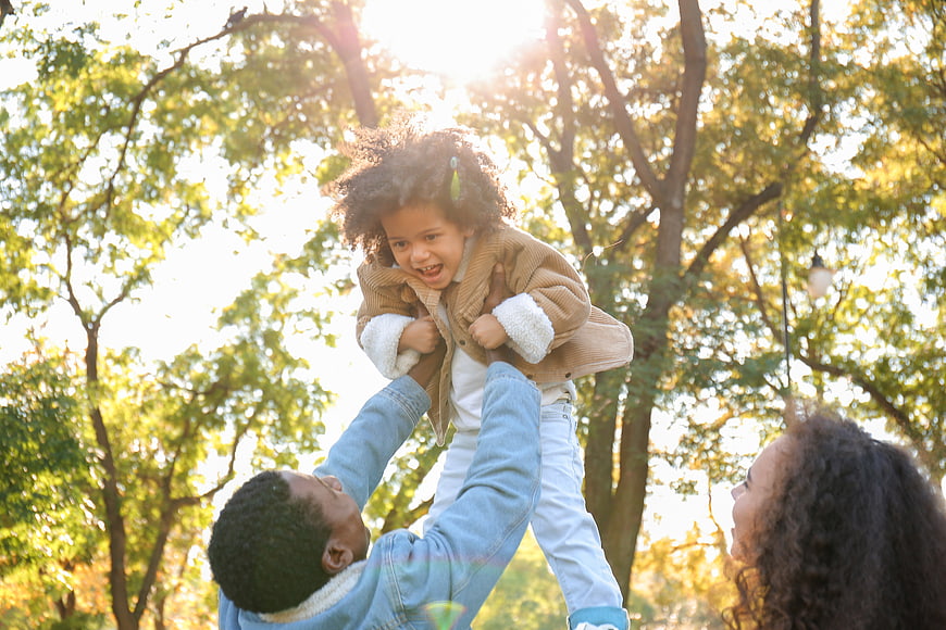 Happy African American Family Playing in Park with Sunlight