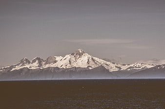 Snow-Capped Mountain Range Over Dark Water