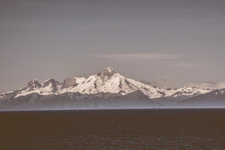 Snow-Capped Mountain Range Over Dark Water