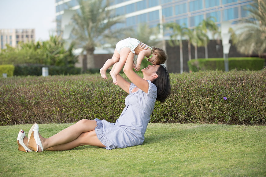 Happy mother lifting baby in park