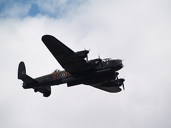 Vintage Avro Lancaster Bomber Flying in Cloudy Sky