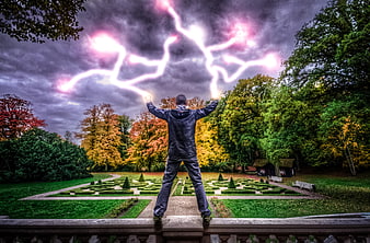 Man summoning pink lightning in autumn park