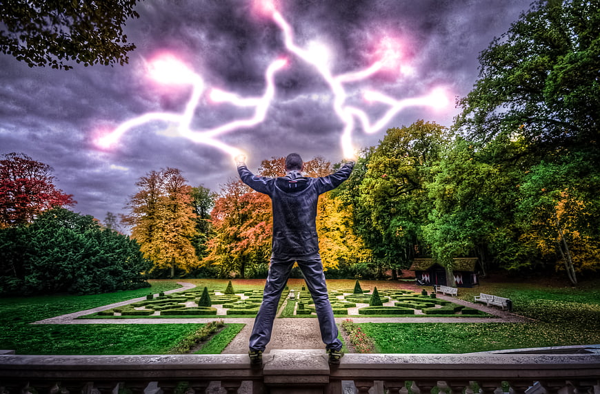 Man summoning pink lightning in autumn park
