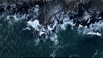 Aerial View of Waves Crashing on Rocky Coastline