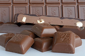 Broken milk chocolate bar with hazelnuts and scattered pieces