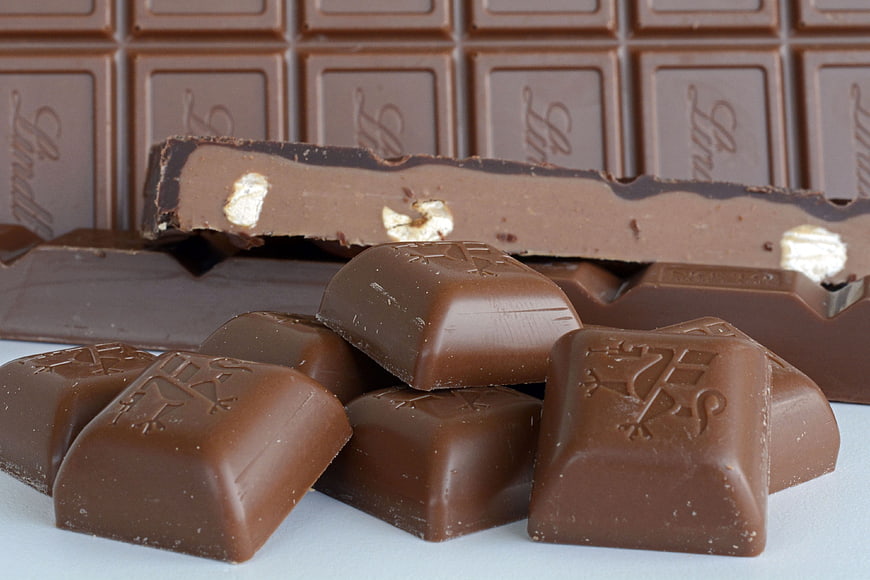 Broken milk chocolate bar with hazelnuts and scattered pieces