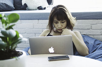 Woman working on laptop while relaxing on beanbag