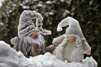 Two Knitted Gnome Figurines Sitting Together In Snow