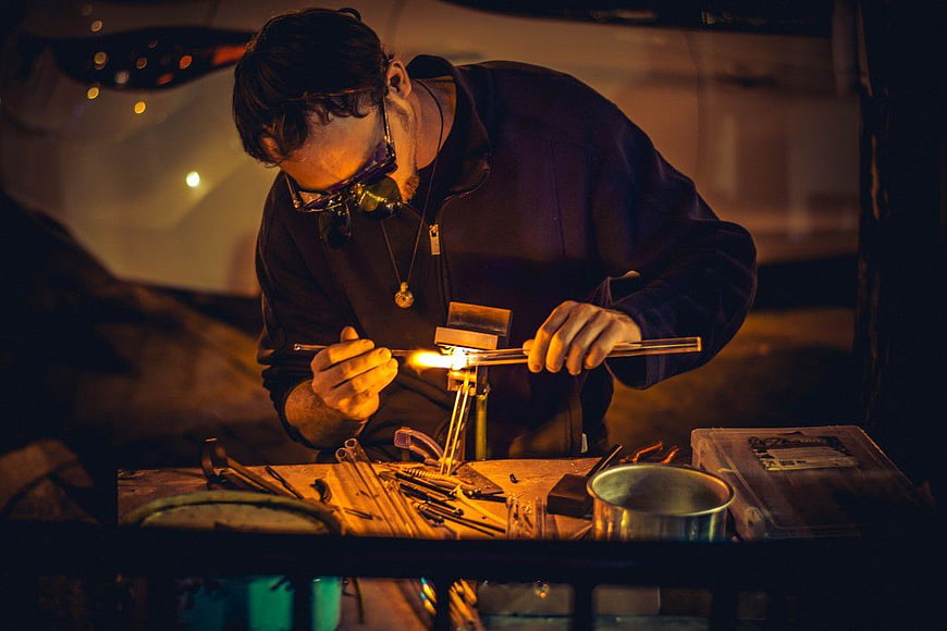 Glassblower Heating Tube with Torch at Night