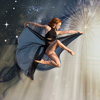 Dancer in black leotard with flowing fabric and fireworks background