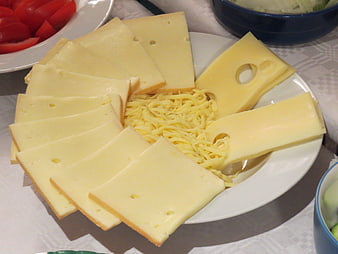 Assorted Swiss Cheese Slices and Shreds on White Plate