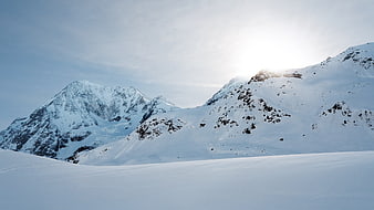 Snowy Mountain Peaks with Sunlight and Blue Sky