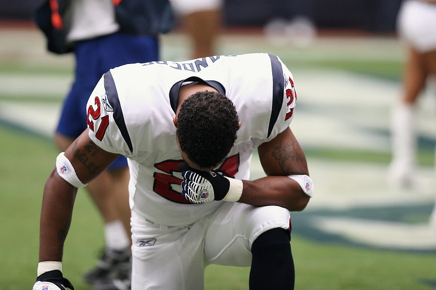 NFL Football Player Kneeling in Prayer on Field