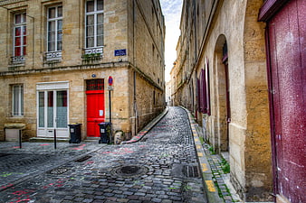 Narrow cobblestone street in old European town with red door