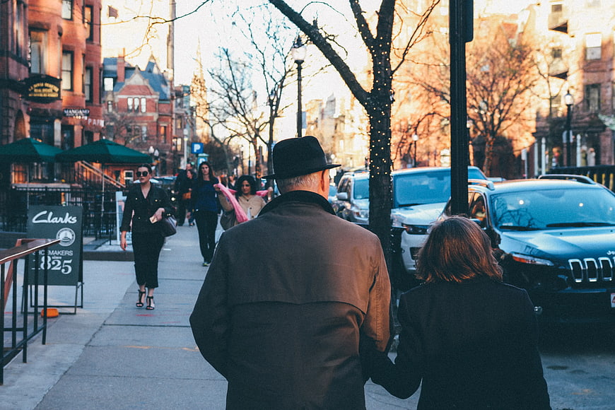 Couple walking down city street in winter afternoon
