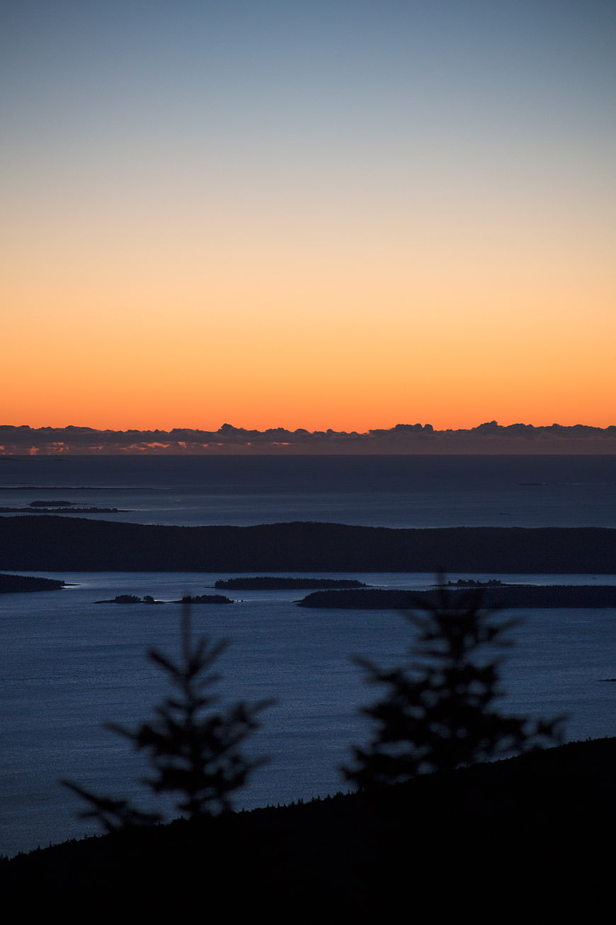 Serene Sunset Over Ocean Islands with Silhouetted Trees
