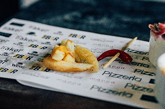 Gourmet potato wedges with chili garnish on restaurant menu