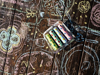 Colorful Chalk Sticks on Wooden Background with Drawings