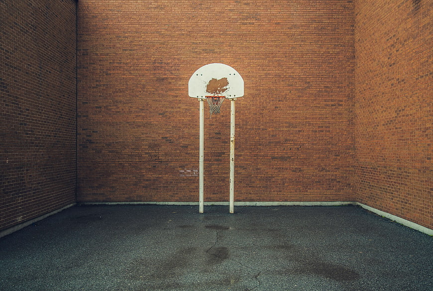Empty Basketball Hoop Against Red Brick Wall