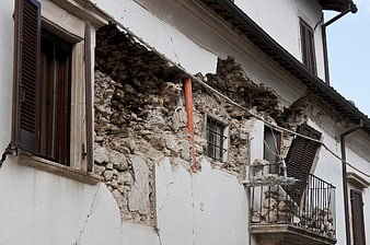 Damaged building facade with collapsed wall and rubble