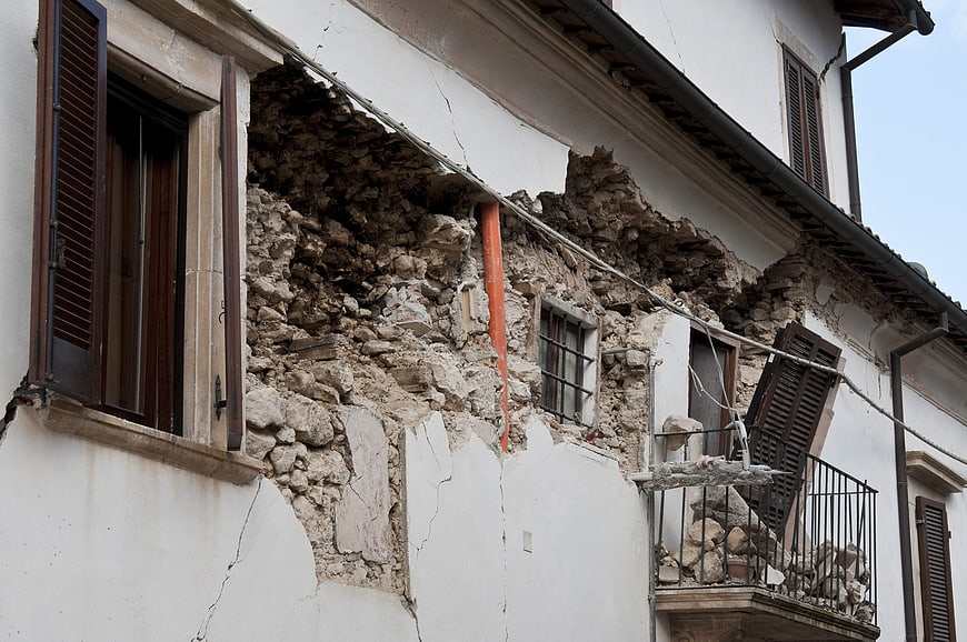 Damaged building facade with collapsed wall and rubble