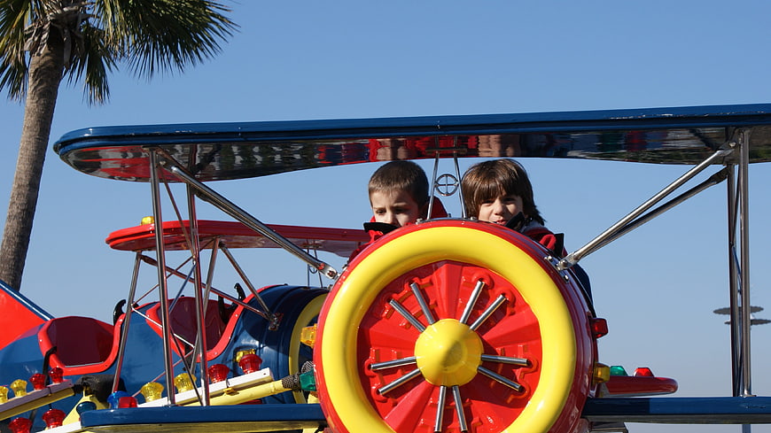 Two children riding a colorful airplane carnival ride