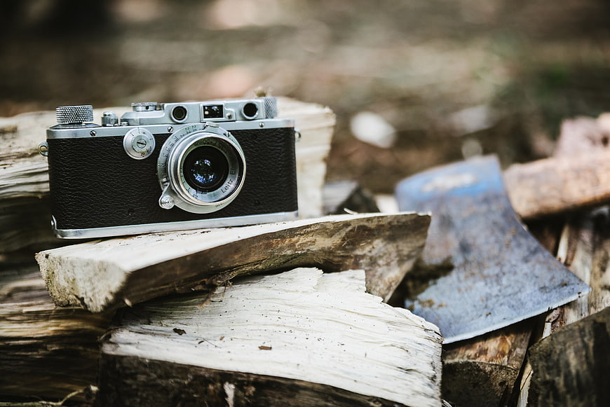 Vintage Camera on Firewood with Axe