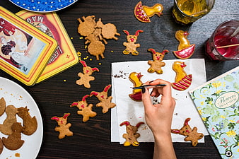 Top view of hand decorating Easter gingerbread cookies
