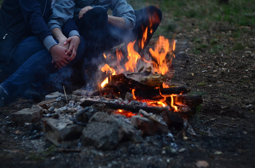 Couple Sitting by Campfire at Twilight