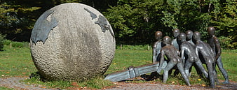Outdoor Sculpture of Children Pushing a Large Stone Globe